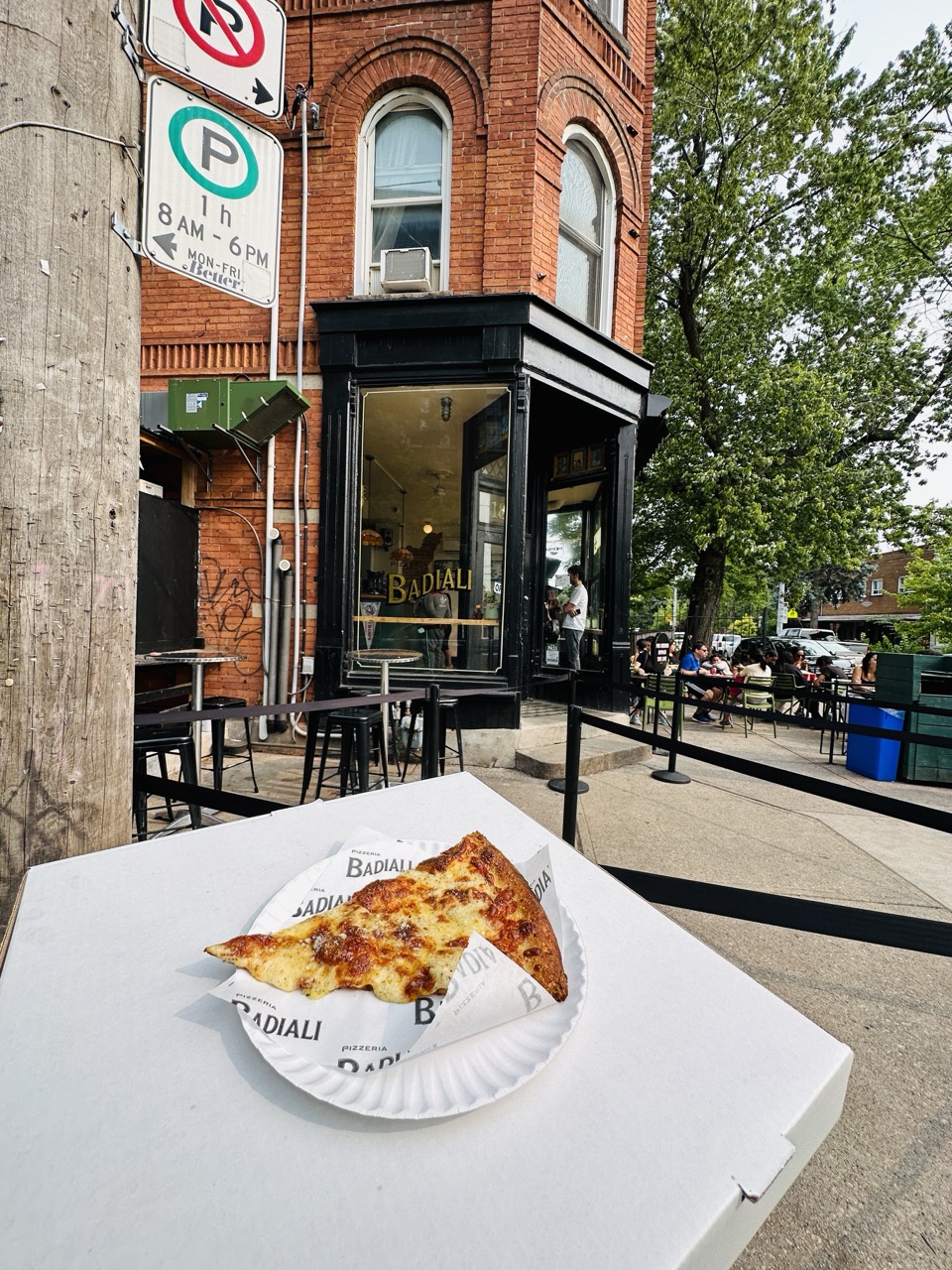 Image of the pizza slice outside of the pizza store